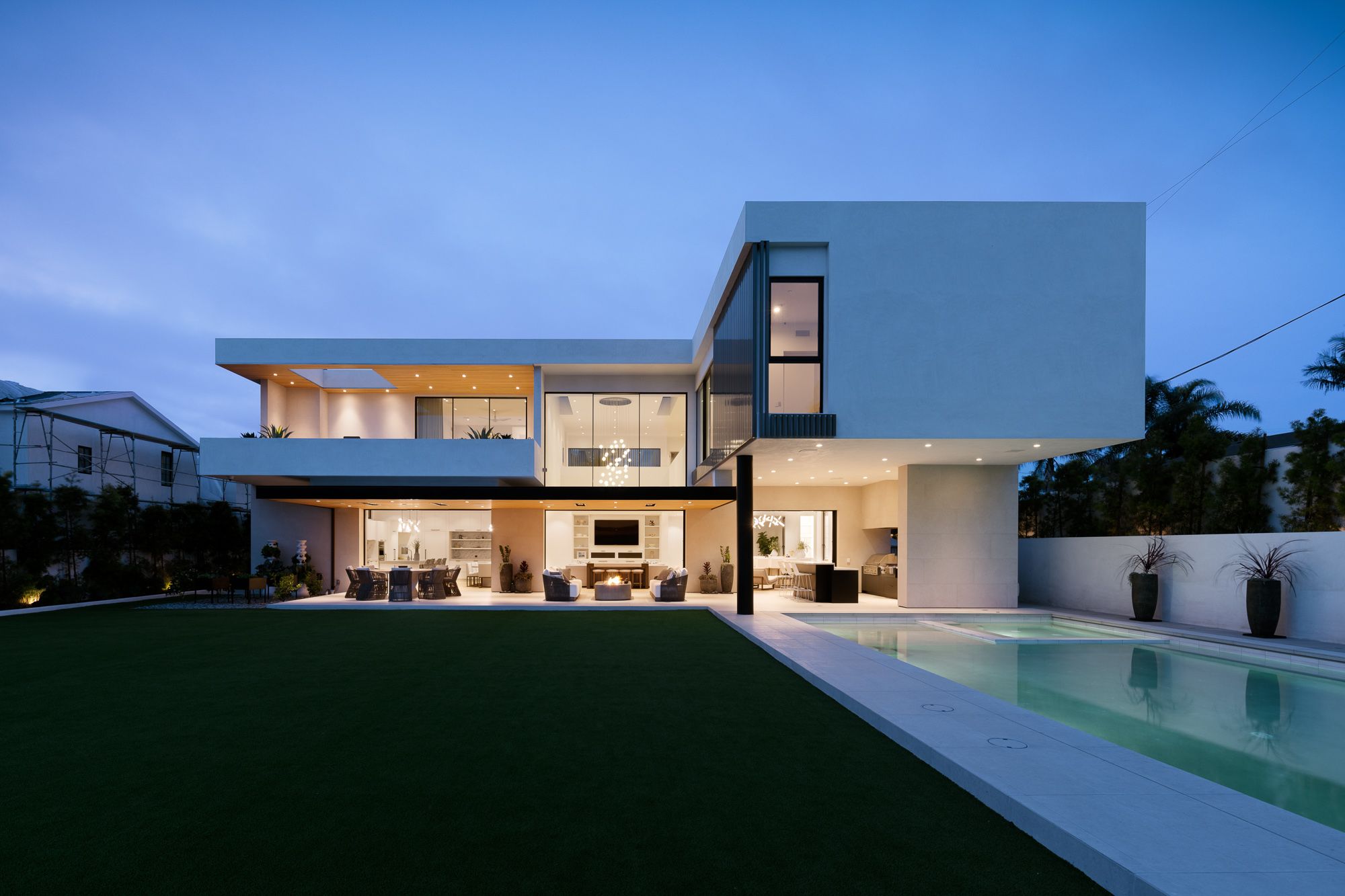 Manhattan Compound at dusk with pool and lawn