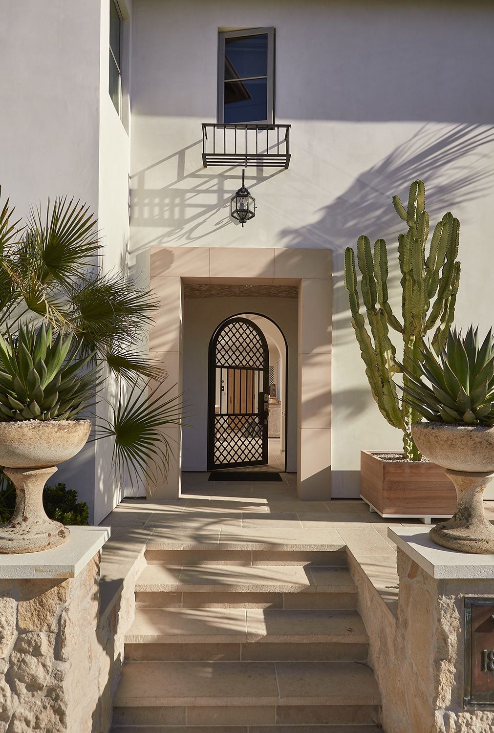 Spanish style entry with arched door and cacti